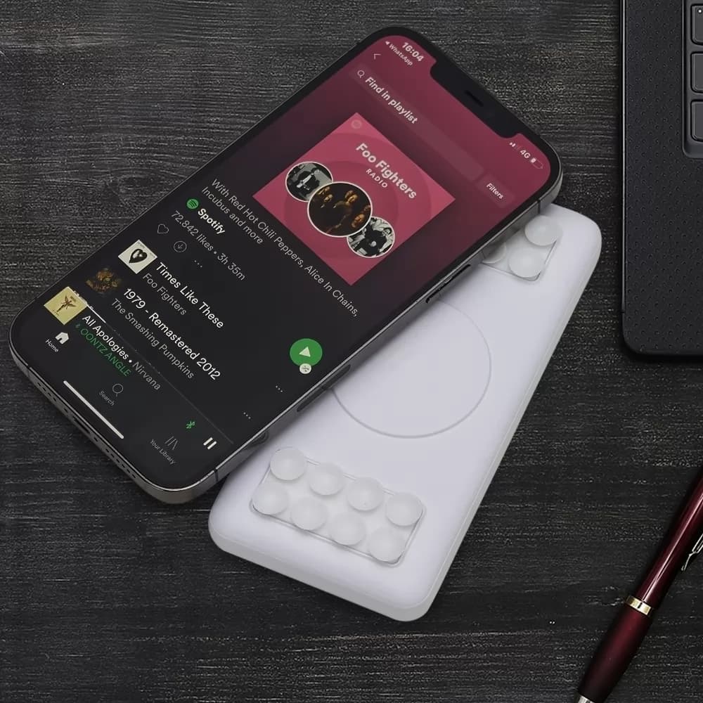 Power bank carregamento por indução branco com ventosas de fixação posicionado junto a smartphone