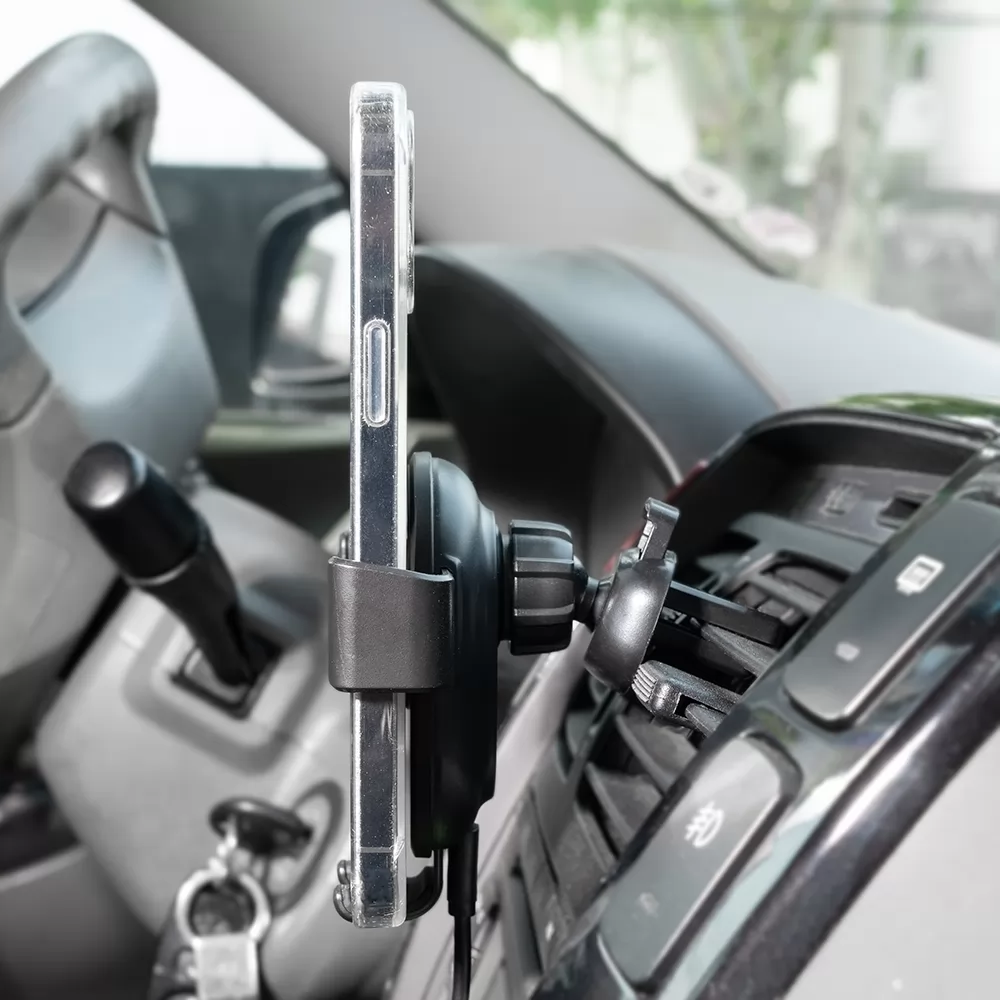 Suporte veicular com carregamento por indução preto instalado na saída de ar do carro segurando celular