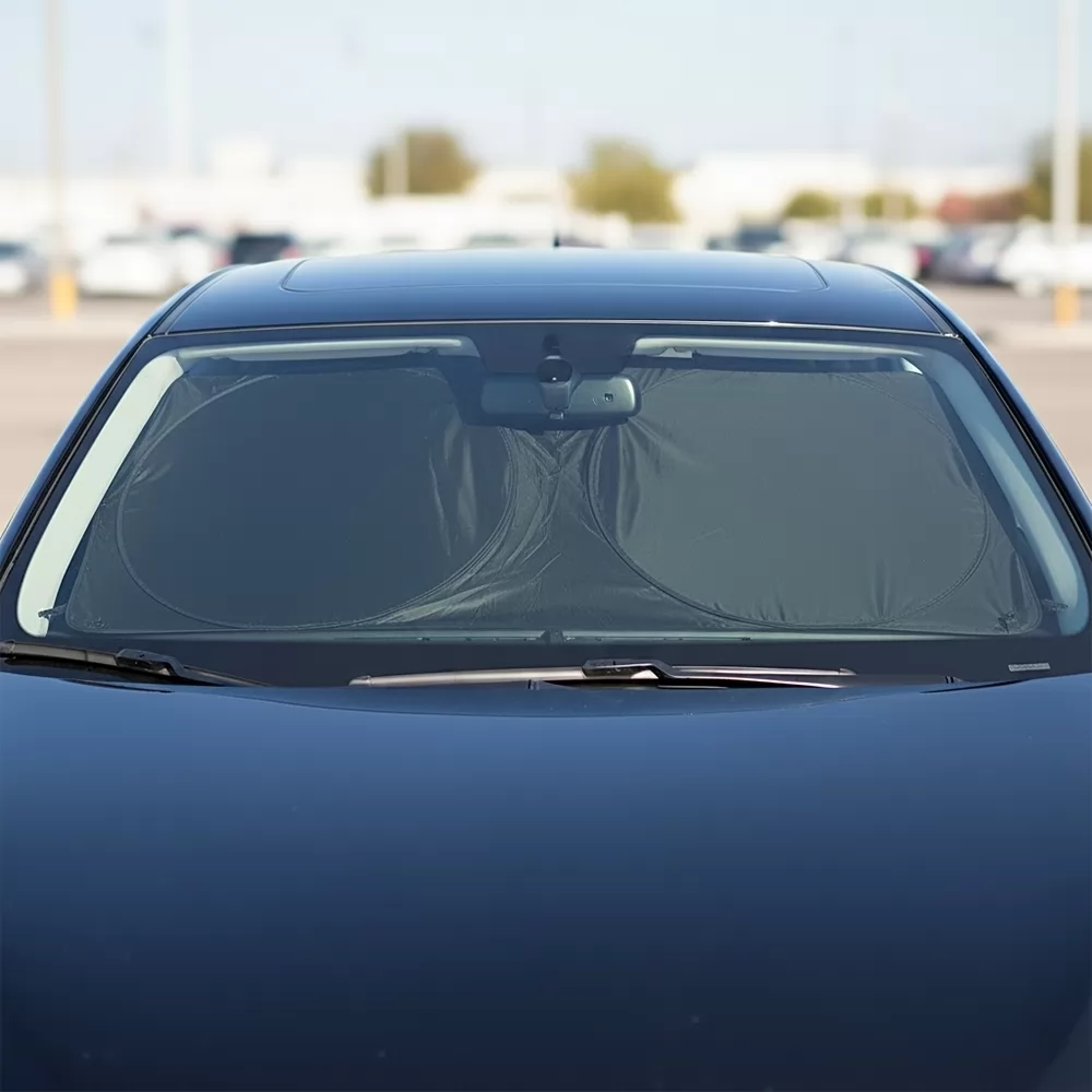 Protetor solar de para-brisa preto instalado no vidro dianteiro de um carro em estacionamento