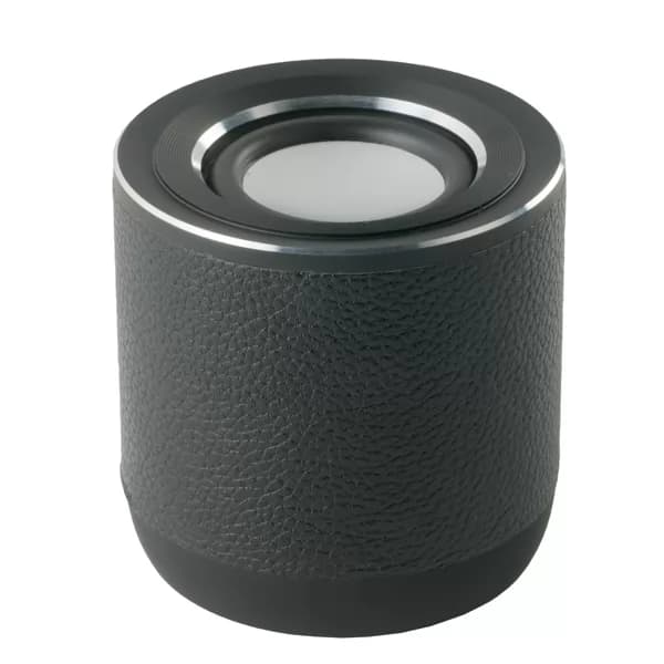 Caixa de som bluetooth Spring em alumínio preta vista de cima ao lado de canetas e cadernos sobre mármore