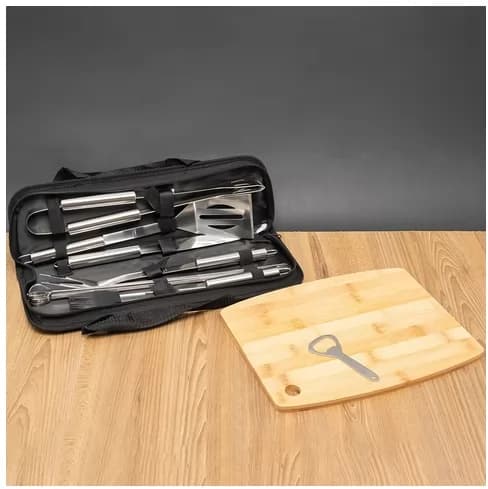 Kit churrasco com estojo preto aberto, utensílios em inox e tábua de madeira com abridor de garrafa