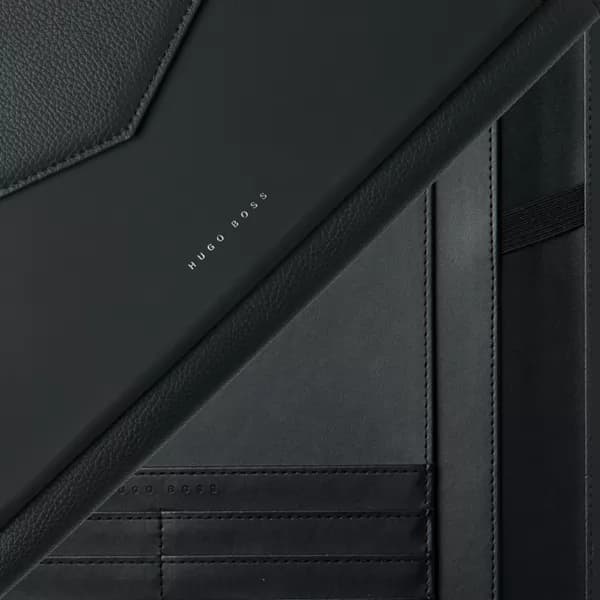 Detalhe em close-up de pasta A5 para organização preta em material sintético com divisórias internas