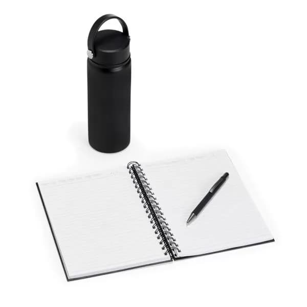 Kit executivo preto com garrafa de inox, caderno espiral aberto e caneta sobre fundo branco
