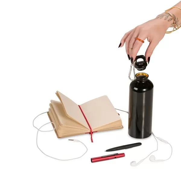 Kit com caderno aberto, fone de ouvido, canetas e garrafa squeeze preta sendo aberta por uma mão