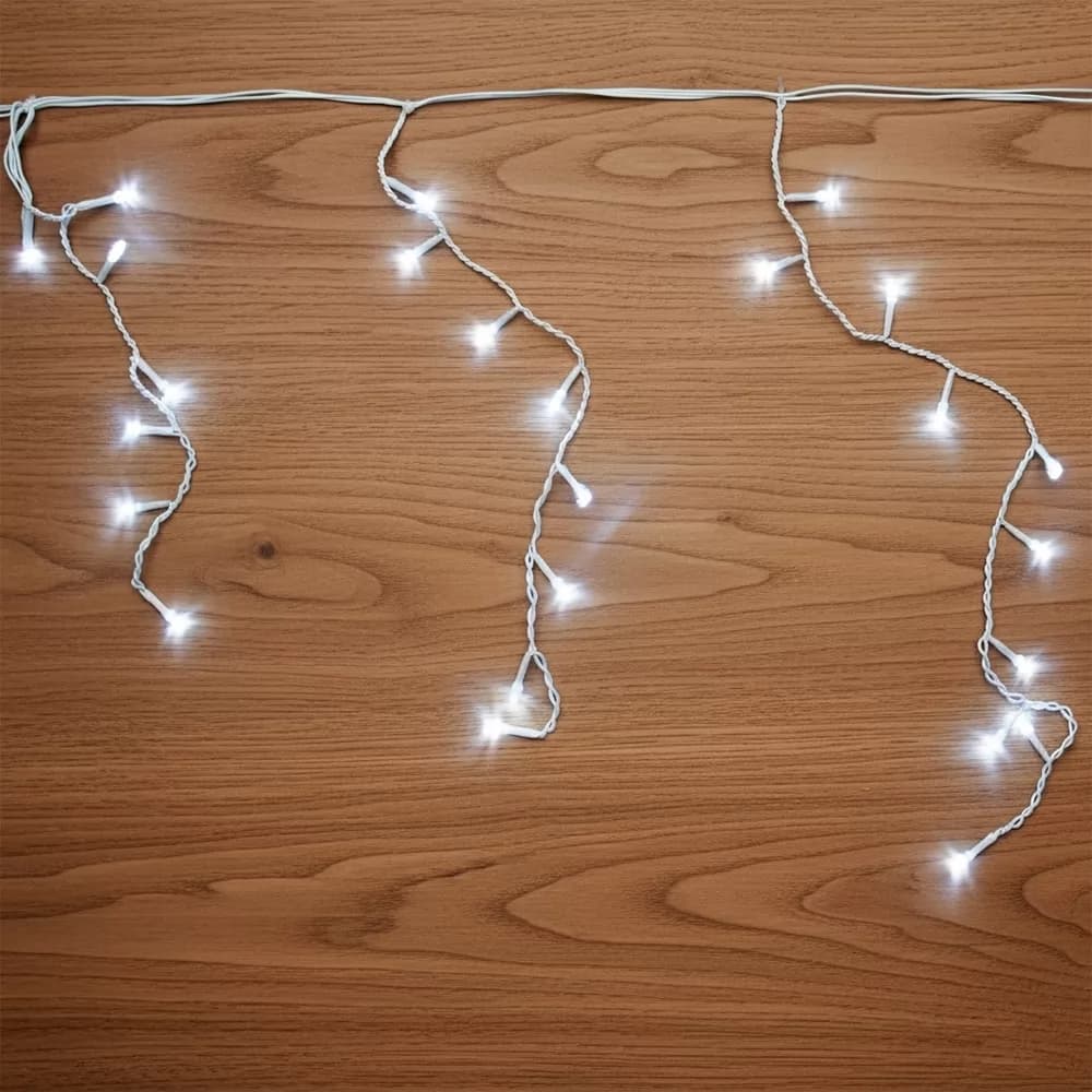 Cascata de LED frio com luzes brancas acesas e fios brancos suspensa sobre fundo amadeirado