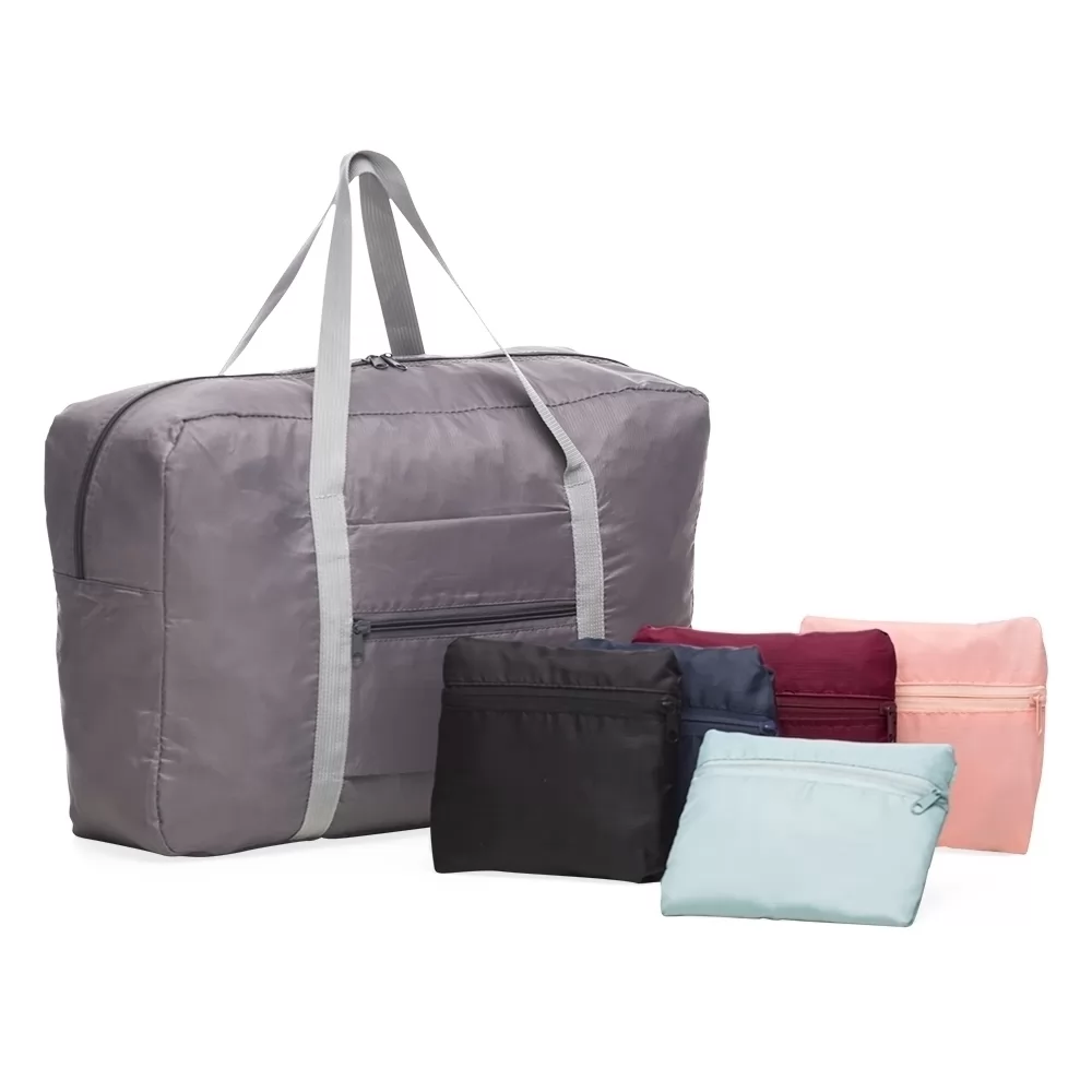 Bolsa de viagem dobrável cinza aberta, acompanhada por modelos dobrados em diferentes cores.