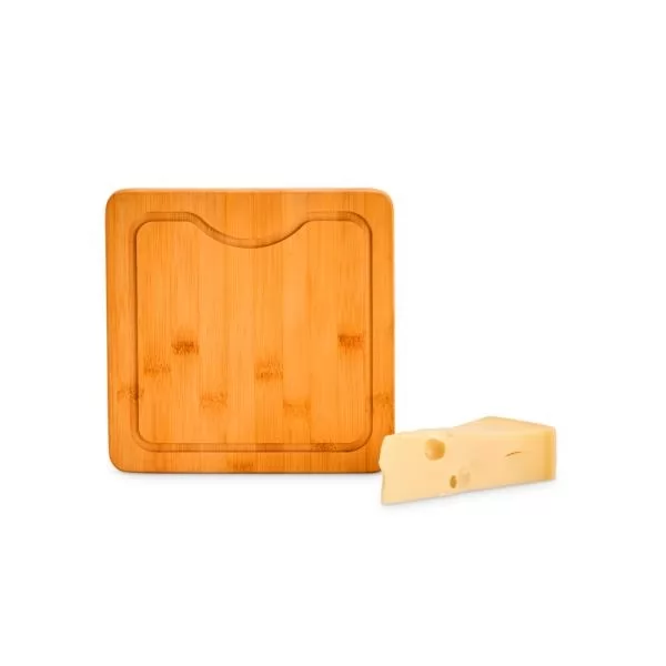 Tábua em bambu quadrada com canaleta ao lado de um pedaço de queijo em fundo branco